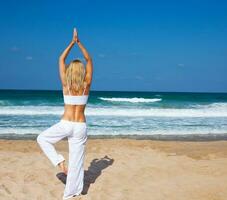 salutare yoga esercizio su il spiaggia foto