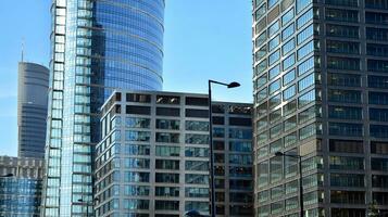 moderno ufficio edificio con bicchiere facciata su un' chiaro cielo sfondo. trasparente bicchiere parete di ufficio costruzione. foto