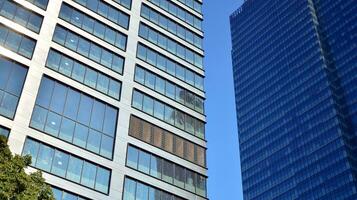 moderno ufficio edificio con bicchiere facciata su un' chiaro cielo sfondo. trasparente bicchiere parete di ufficio costruzione. foto