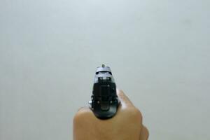 maschio mano Tenere un' 9 mm pistola mentre Avvincente foto