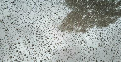 acqua gocce su il cappuccio di il auto dopo il pioggia. foto