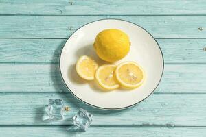 il frutta Limone su il blu tavolo, freddo leggero sfondo foto