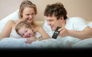 contento famiglia dire bugie nel letto Guardando televisione foto