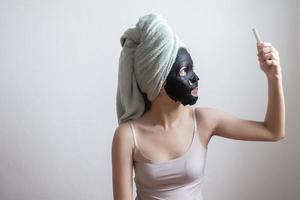 bella donna con maschera facciale nera, concetto di stile di vita foto