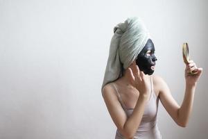 bella donna con maschera facciale nera, concetto di stile di vita foto