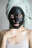 bella donna con maschera facciale nera, concetto di stile di vita foto