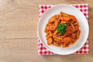 pasta a spirale o spirali con salsa di pomodoro e salsiccia - stile italiano foto