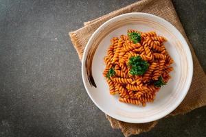 pasta a spirale o spirali con salsa di pomodoro e salsiccia - stile italiano foto