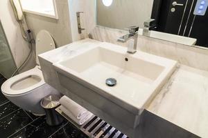 lavello bianco e decorazione del rubinetto in bagno