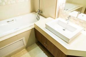 lavello bianco e rubinetto e decorazione della vasca da bagno in bagno foto