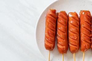 spiedino di salsiccia fritta su piatto bianco foto