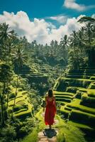 un' giovane femmina turista nel un' rosso vestito ammirazione il mozzafiato tegalalang riso terrazza nel bali Indonesia foto