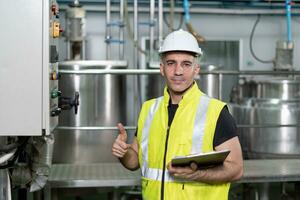 ritratto ingegneri o fabbrica manager indossare sicurezza casco ispezionare il macchine nel il produzione linea. il ispettore ha aperto il macchina per test il sistema per incontrare il standard. macchina Manutenzione foto