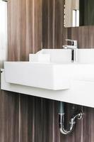 lavabo moderno bianco e rubinetto in bagno foto