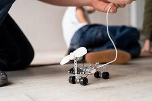 giovani ragazzi che si divertono a costruire auto robot in officina foto