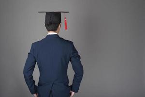 l'uomo d'affari tiene in mano il cappello di laurea, concetto di educazione aziendale foto