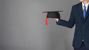 l'uomo d'affari tiene in mano il cappello di laurea, concetto di educazione aziendale foto