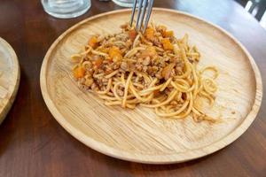 Close up di spaghetti sul piatto di legno foto