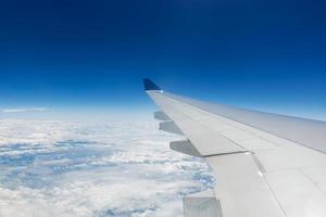 bella vista di cloudscape e ala di aeroplano vista attraverso il finestrino di un aeroplano foto