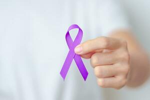 donna Tenere viola nastro per violenza, pancreatico, esofageo, testicolare cancro, alzheimer, epilessia, lupus, sarcoidosi e fibromialgia. consapevolezza mese e mondo cancro giorno concetto foto