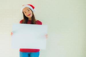 le belle giovani donne asiatiche del ritratto mostrano la carta bianca in bianco del bordo con lo spazio della copia foto