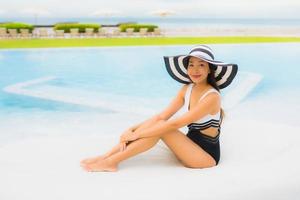 ritratto belle giovani donne asiatiche sorriso felice rilassarsi intorno alla piscina foto