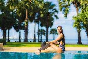 ritratto belle giovani donne asiatiche sorriso felice rilassarsi intorno alla piscina foto