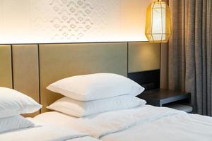 decorazione del cuscino bianco sul letto nella camera da letto del resort dell'hotel foto
