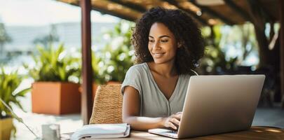 un' bellissimo etnico donna Lavorando remoto su sua il computer portatile a partire dal casa. ai generato foto