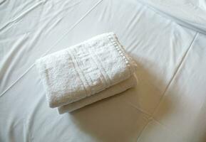 mucchio di bianca pulito asciugamani su il letto foto