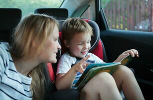 madre e figlio con un' libro nel il auto foto