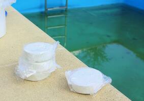 bianca il giro cloro compresse per disinfezione e purificazione di acqua nel nuoto piscine. preparazione per nuoto nel il estate stagione. foto