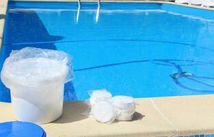 bianca il giro cloro compresse per disinfezione e purificazione di acqua nel nuoto piscine. preparazione per nuoto nel il estate stagione. foto