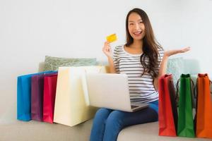 ritratto belle giovani donne asiatiche con carta di credito cellulare o computer per lo shopping foto