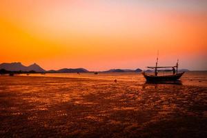 spiaggia tropicale al tramonto silhouette sfondo cielo arancione in thailandia foto