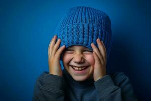 un' ragazzo con un' blu a maglia cappello è ridendo su sfondo foto