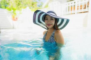 ritratto bella giovane donna asiatica sorriso felice rilassarsi intorno alla piscina all'aperto foto