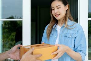 contento sorridente donna riceve scatole pacco a partire dal Corriere nel davanti Casa. consegna uomo Spedire consegnare esprimere. in linea acquisti, carta contenitori, porta via, postino, consegna servizio, pacchi foto