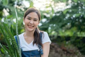 bellissimo asiatico donna femmina pianta e prendere cura alberi nel vasi di fiori come passatempo e relax. pianta i saldi piccolo attività commerciale. Casa giardino, giungla, giardiniere, fiore decorazione, verde, contento stile di vita nel casa foto