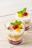 mango fresco fatto in casa e lampone fresco con yogurt e muesli - stile di cibo sano foto