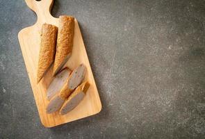 torta di pesce cinese fritta o linea di polpette di pesce su tavola di legno foto