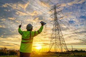 ingegnere successo dopo controllo a il energia stazione per pianificazione opera di generando elettricità a partire dal il alta tensione trasmissione Torre a tramonto. foto