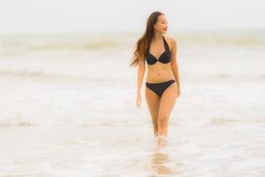 ritratto bella giovane donna asiatica indossare bikini sulla spiaggia mare oceano foto