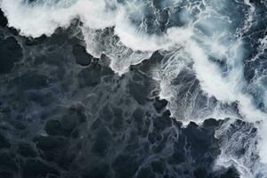 schiuma su il superficie di il mare. astratto sfondo. aereo Visualizza di onde su nero sabbia spiaggia, ai generato foto