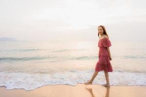 ritratto bella giovane donna asiatica sorriso felice tempo libero sulla spiaggia mare e oceano foto