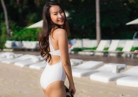ritratto bella giovane donna asiatica felice e sorridente sulla spiaggia mare e oceano foto