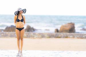 ritratto bella giovane donna asiatica indossare bikini intorno alla piscina in hotel resort quasi mare oceano spiaggia foto