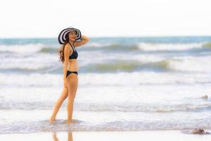 ritratto bella giovane donna asiatica indossare bikini sulla spiaggia mare oceano foto