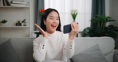 asiatico donna giocando un' gioco su smartphone foto