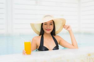 ritratto bella giovane donna asiatica sorriso felice rilassarsi intorno alla piscina all'aperto foto
